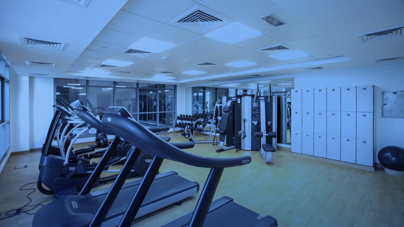 Gimnasio amplio con caminadoras y máquinas de ejercicio sin personas
