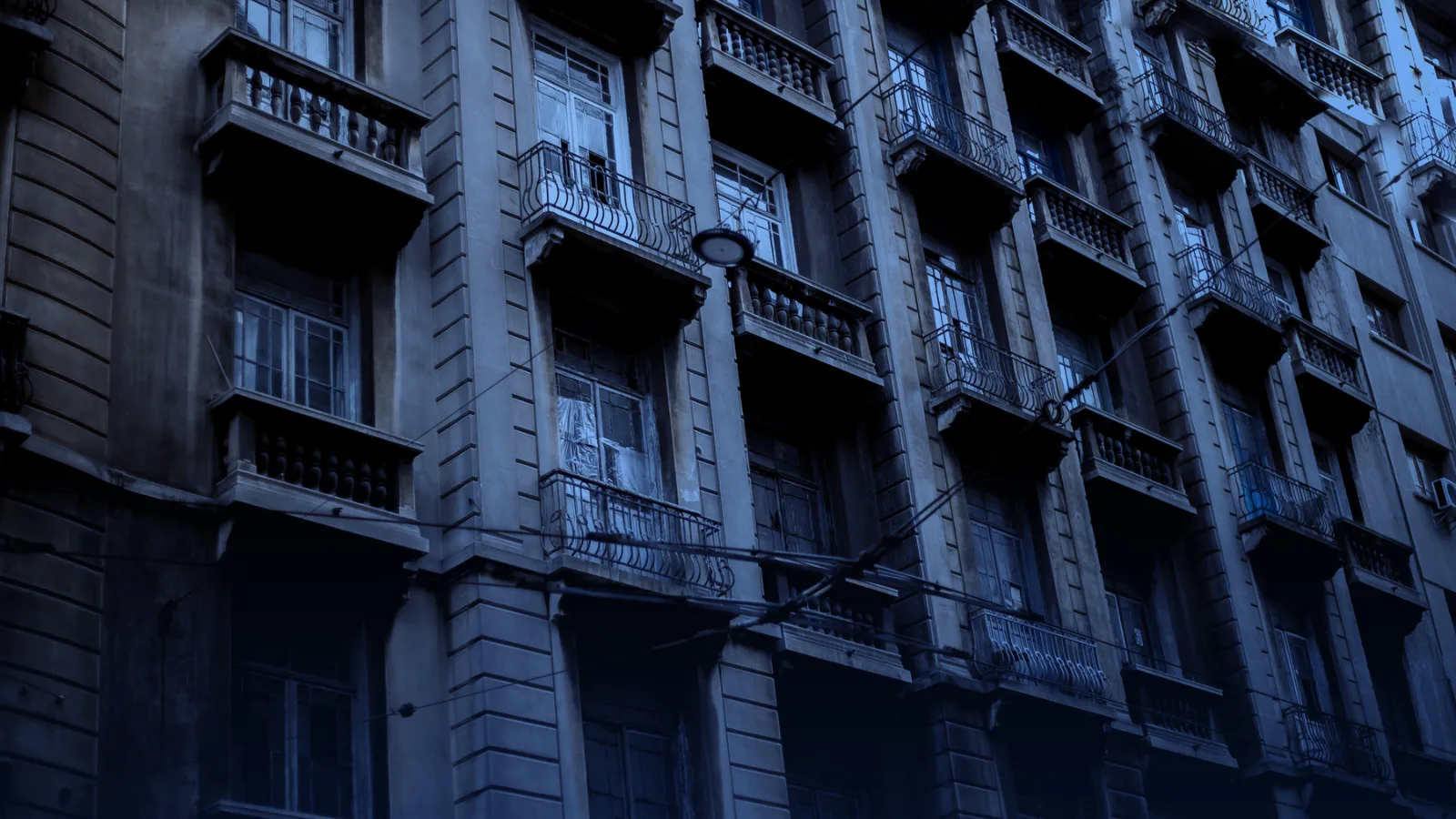 Fachada de un edificio residencial antiguo con balcones y ventanas