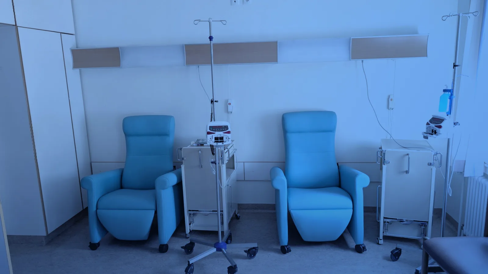 Sala de tratamiento vacía con sillones reclinables y equipo