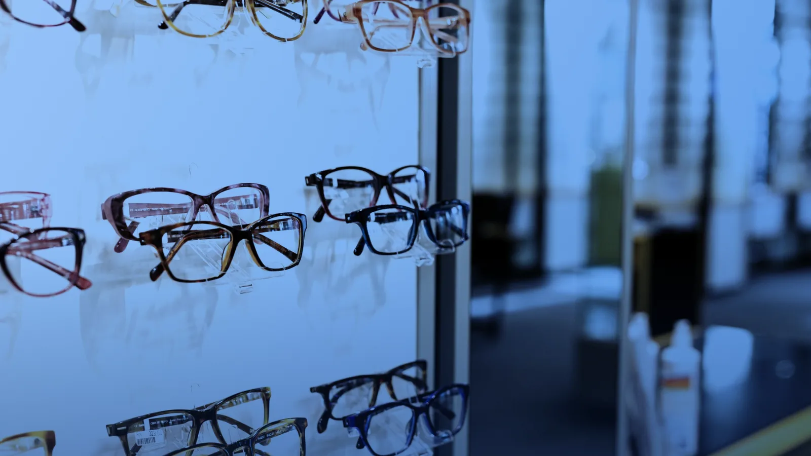 Anteojos de distintos modelos exhibidos en una repisa de vidrio