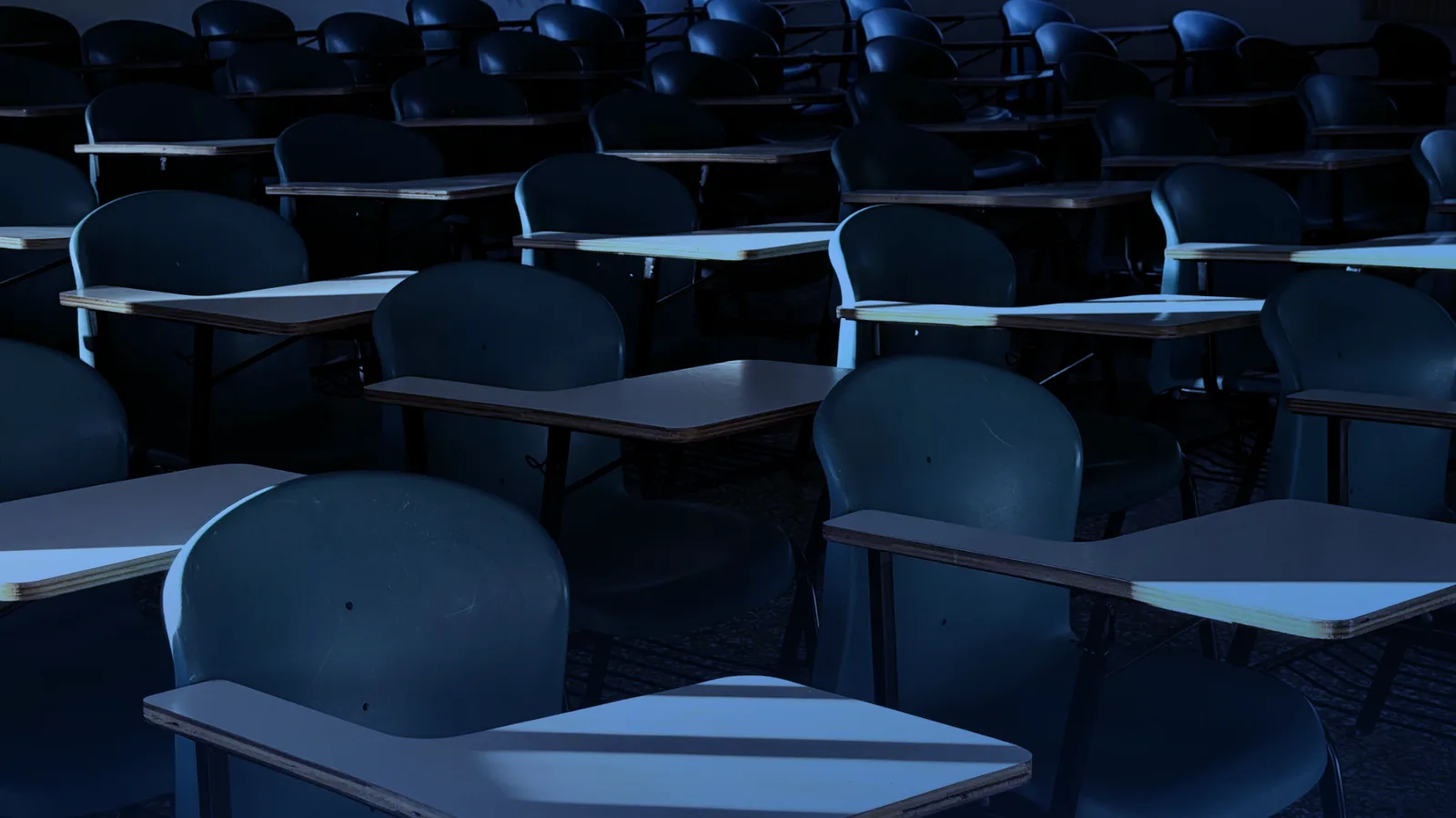 Aula vacía con pupitres iluminados por la luz del sol