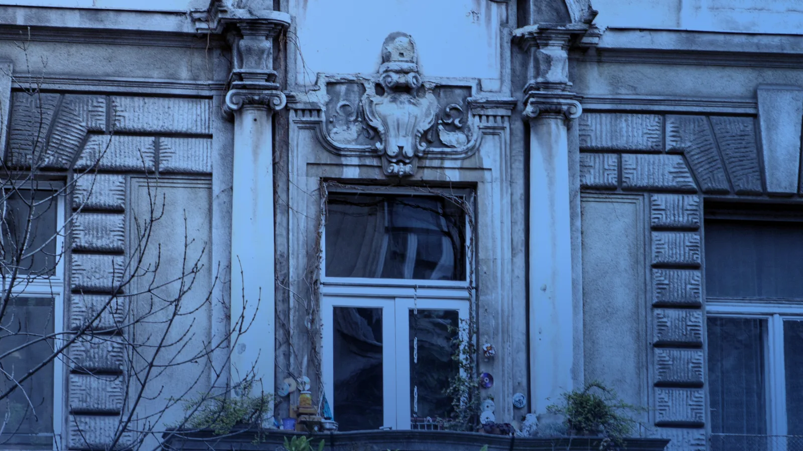 Fachada de un edificio antiguo con balcón y detalles ornamentales