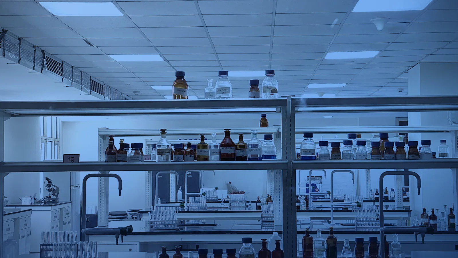 Laboratorio luminoso con estantes de frascos y cielo raso modular
