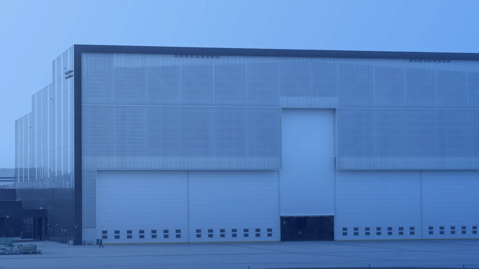 Exterior de una bodega industrial moderna con grandes portones