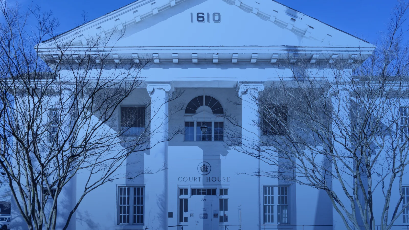 Fachada neoclásica blanca de un edificio judicial con columnas
