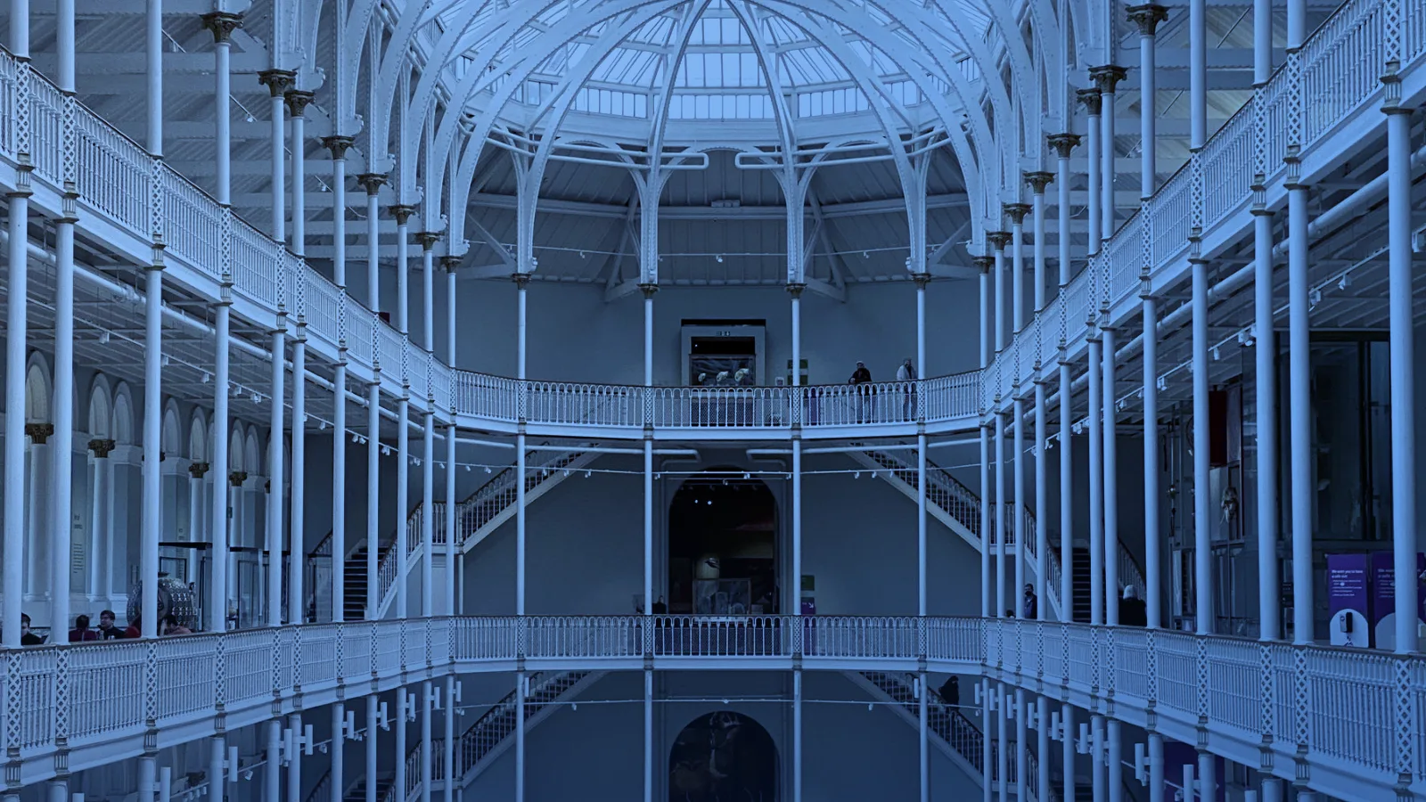Gran salón de museo con techo de cristal y galerías en varios niveles