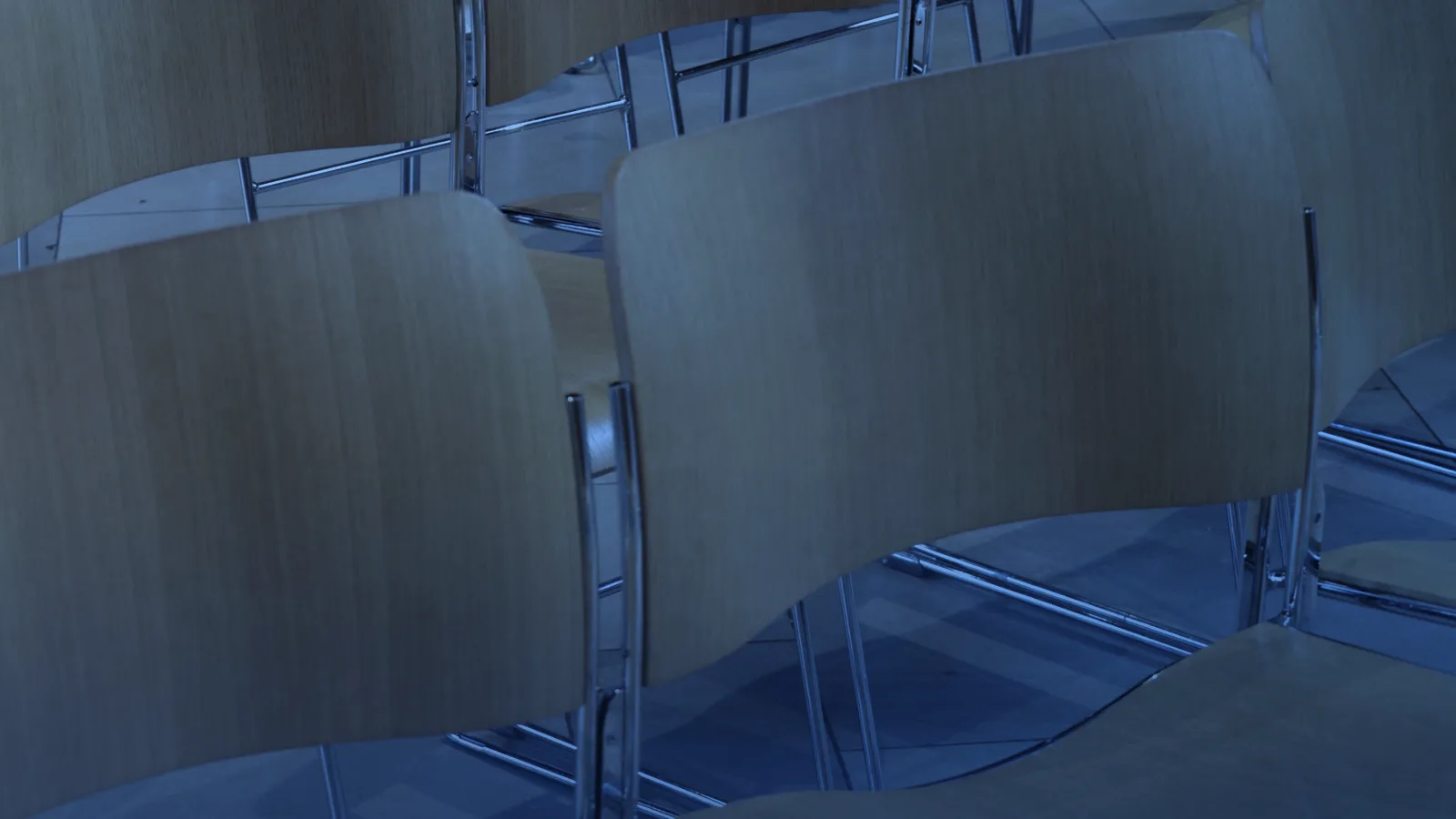 Filas de sillas de madera ordenadas en un salón interior