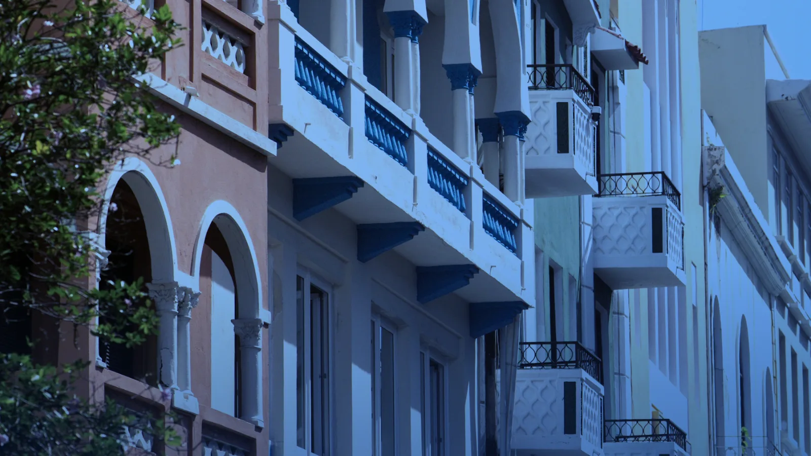 Fachadas coloniales de colores con balcones y arcos